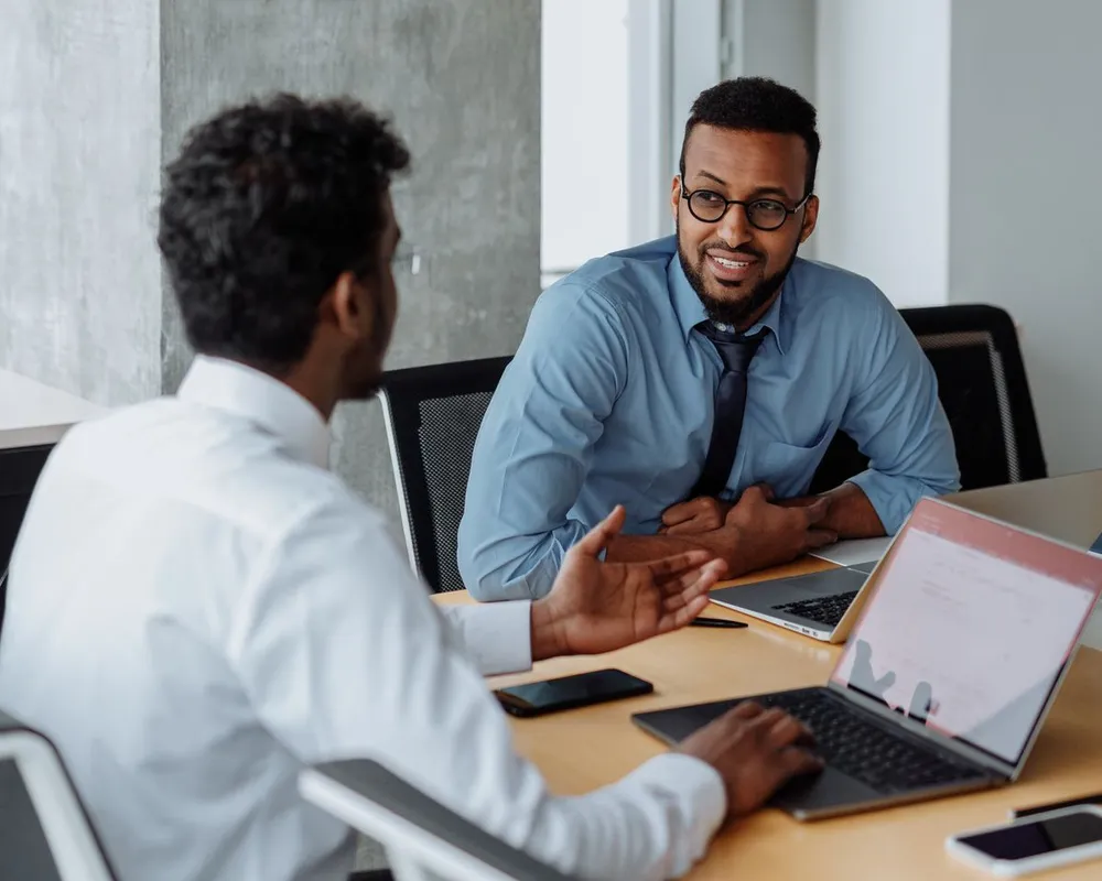 Two professionals having a friendly conversation across a desk